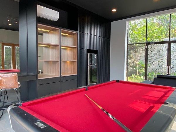 Ruang biliar dengan meja billiard, bar dan kabinet hijau tua bergaris